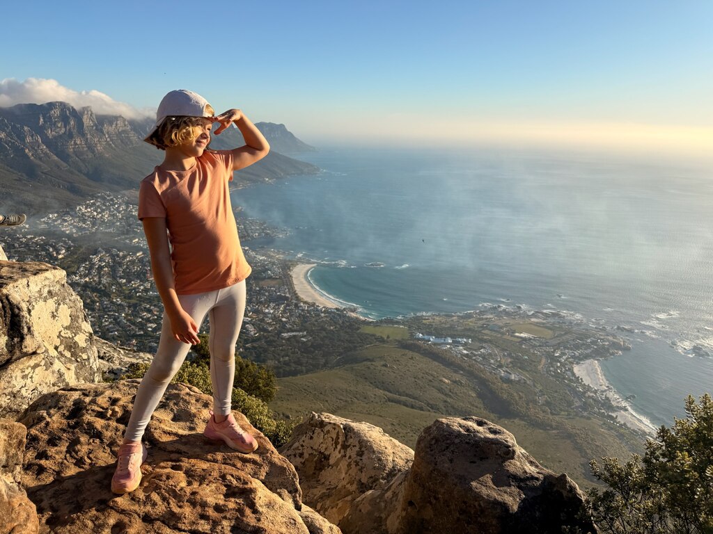 Young girl standing on the top of a mountain and enjoying the view.
