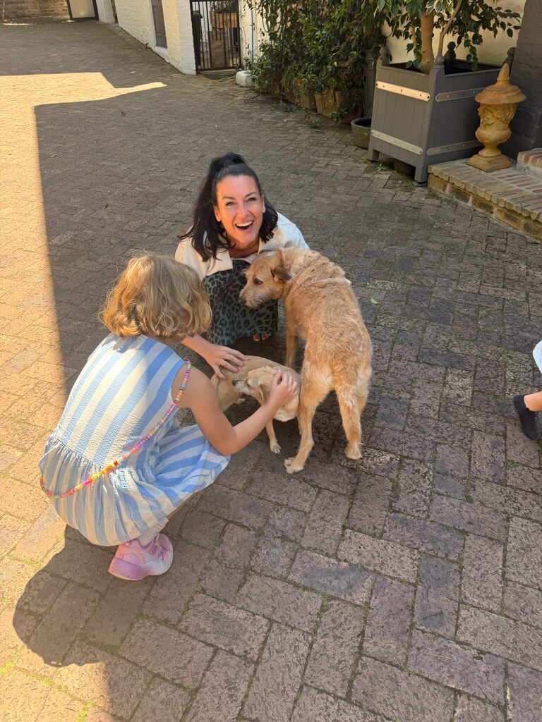 Living in Cape Town with Kids – What It’s Really Like 6 A mum and daughter cuddling with two dogs, part of living in cape town with kids.