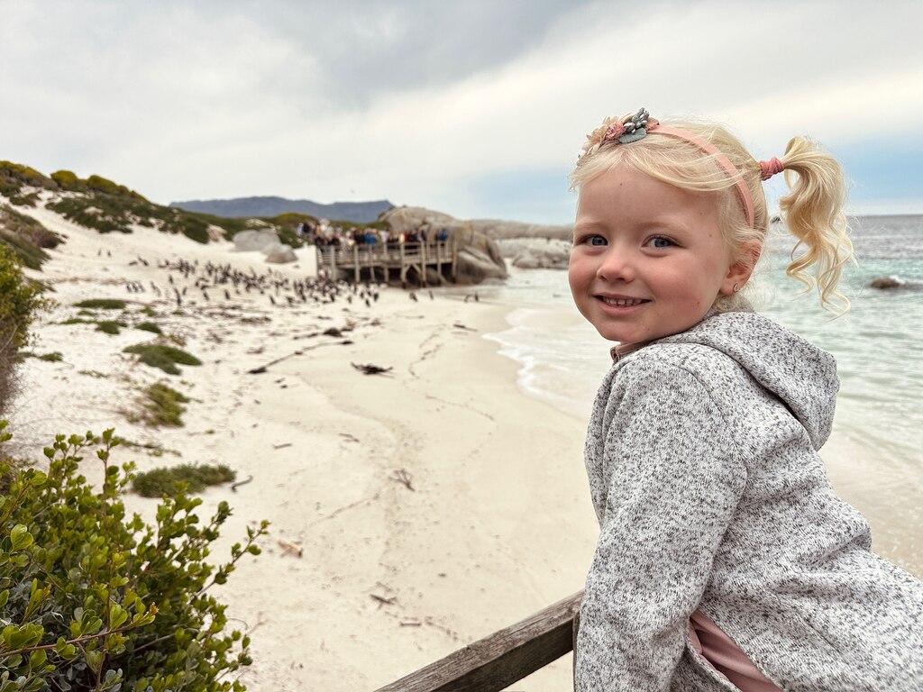 Living in Cape Town with Kids – What It’s Really Like 21 A young girl in front of a beach with penguins.