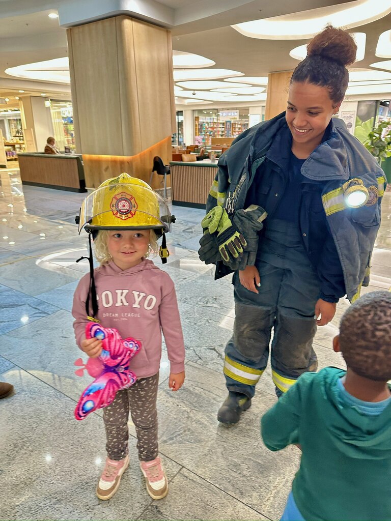 Living in Cape Town with Kids – What It’s Really Like 14 A young girl wearing the helmet of a firefighter.