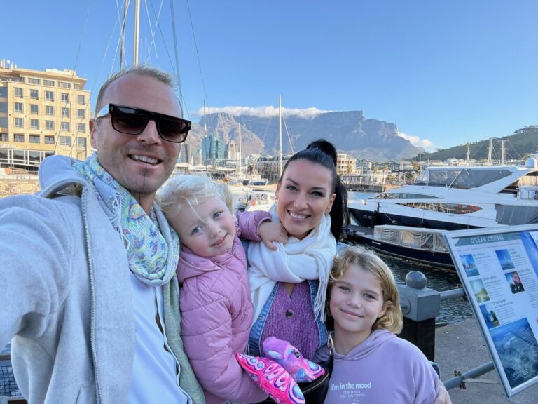 A family of four with mountains in the background.
