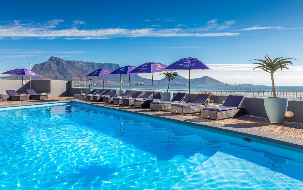 Living in Cape Town with Kids – What It’s Really Like 10 Poolside view with mountains and umbrellas.