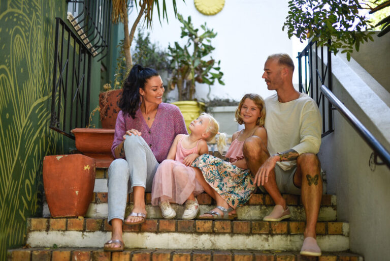 Family of four sitting on stairs.