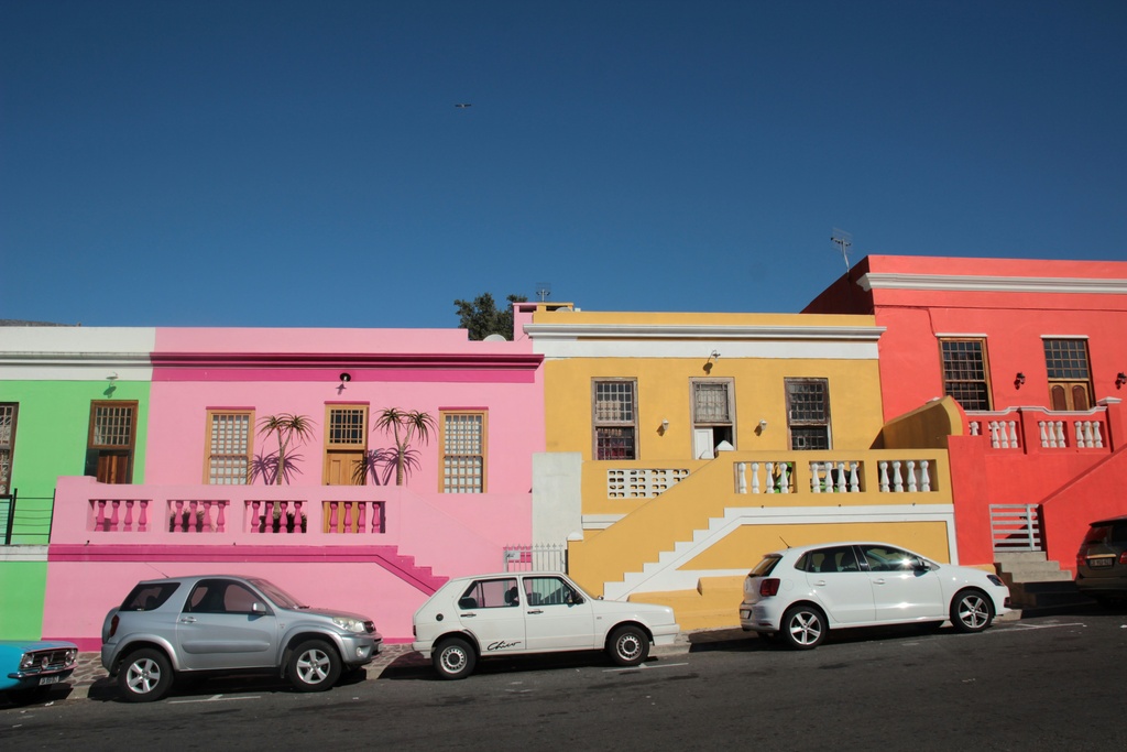 Colorful houses with parked cars.