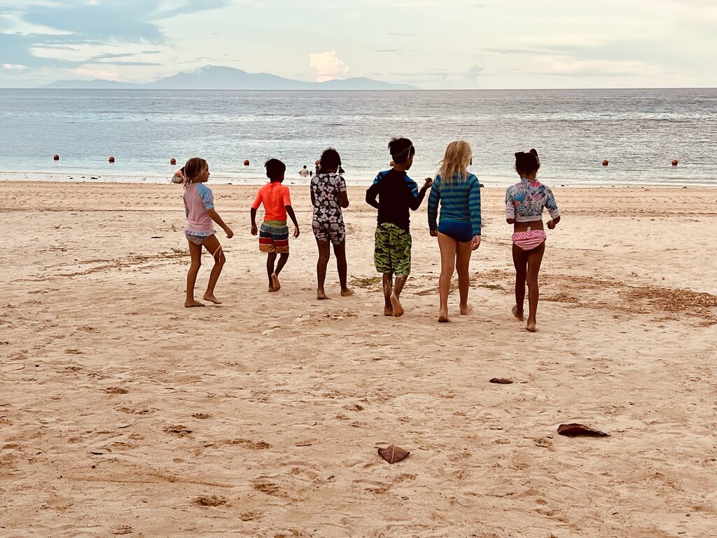 Children walking on a beach.